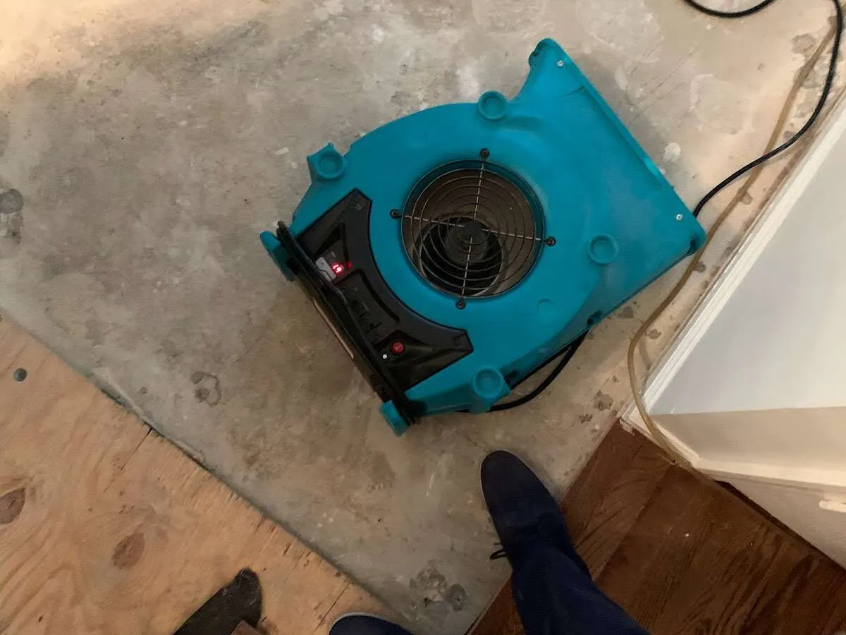Air mover drying subfloor during Commercial Water Damage Restoration in Manchester